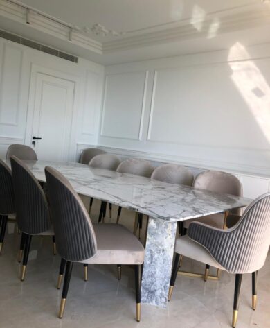 Dining room with marbled top table and 12 quilted armchairs