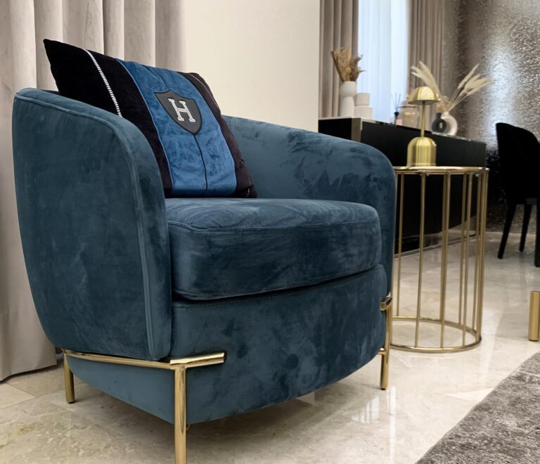 An elegant dark blue armchair with golden stainless steel legs for a splash of luxury