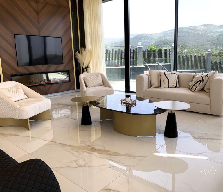 Luxurious interior showcasing the off-white Billionaire sofa with 2 armchairs. In the background sits the custom-made wooden wall facade with built in chimney and TV