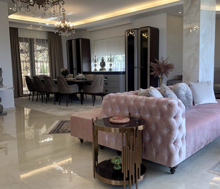 A view of the dining area showcasing the button-tufted side of the pink sofa