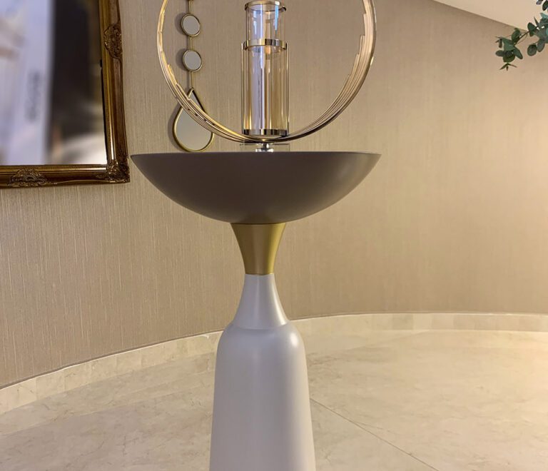 A gold candleholder on top of a white and gold stand/sidetable