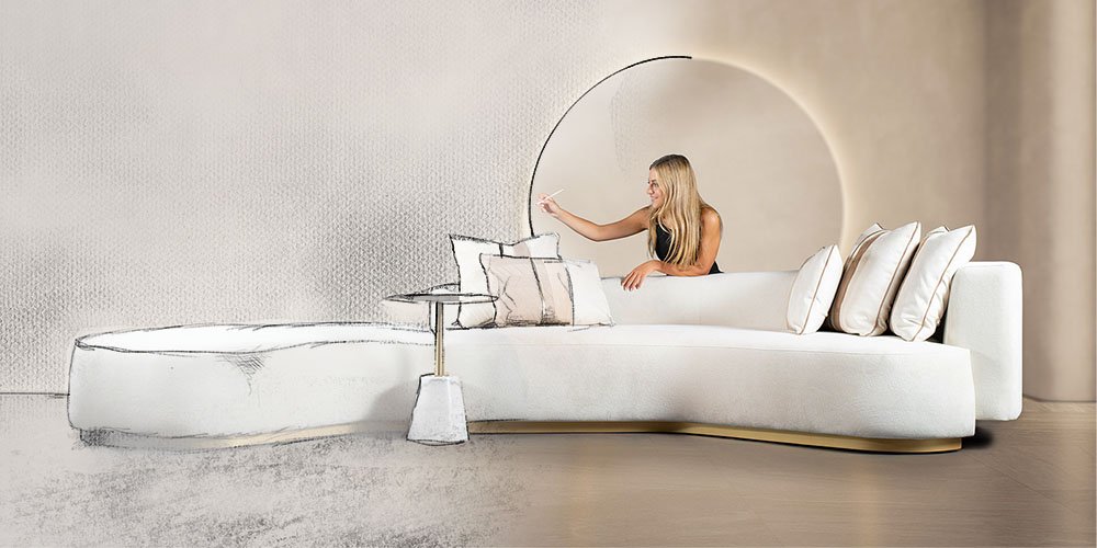 A lady drawing a sketch of a luxurious sofa and wall design that is transforming to reality as she is sitting in the room