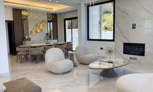 The white second seating area with the elegantly decorated dining room in the background